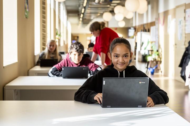 Meisje aan computer in stedelijke basisschool Het Groene Eilandje